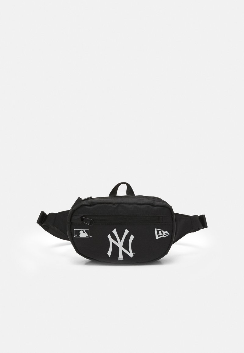 Riñonera negra con un bolsillo delantero con cremallera, presenta un logotipo blanco de los New York Yankees y detalles, fabricada con material duradero.