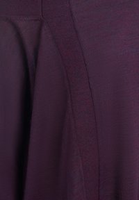 Tessuto in maglia viola con una texture liscia, caratterizzato da una leggera lucentezza e dettagli delle cuciture verticali. Il tessuto cade morbido.