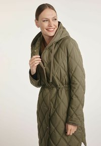 Pikowana oliwkowozielona kurtka z kapturem, ściągaczem w talii i zapięciem na zatrzask/guzy. Posiada diamentowy wzór oraz kontrastowe brązowe wykończenia.