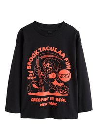 Svart långärmad tröja med en stor orange grafik av en tecknad figur med pumpor och text om Halloween-teman.