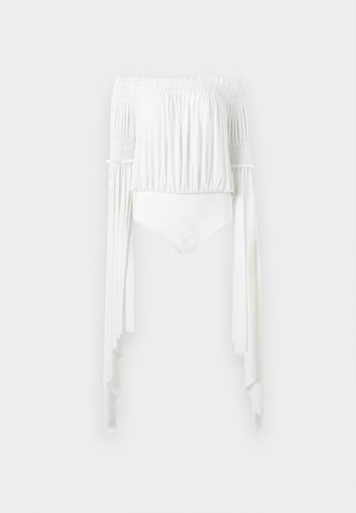 Λευκό τοπ κοντό με ανοιχτούς ώμους, σούρες στο ελαστικό ντεκολτέ και στα μανίκια, μακριά ασύμμετρα ρέοντα μανίκια και εφαρμοστή μέση.