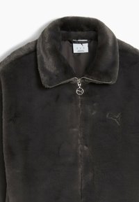 Black faux fur jacket with a zippered front, a stand-up collar, and embroidered logo. Soft texture, sleek design, and subtle sheen.