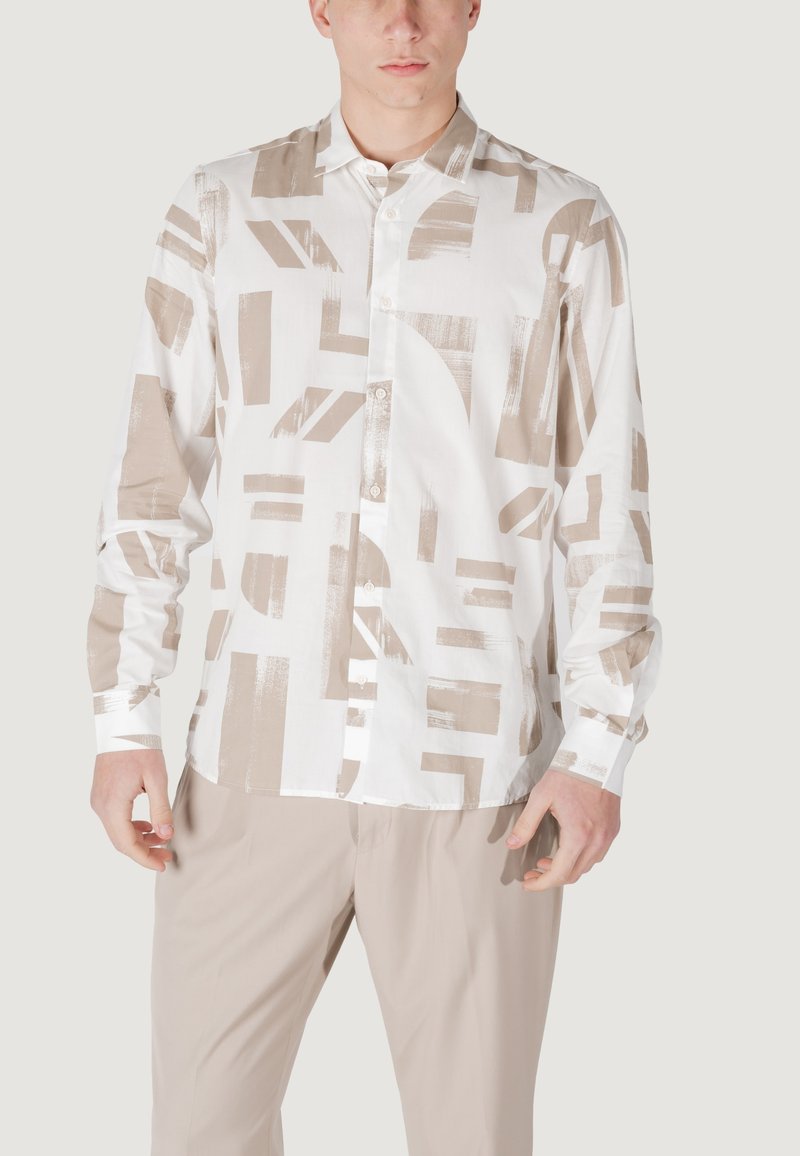 Camisa blanca de botones con patrones abstractos en beige, hecha de una tela ligera. Presenta un cuello y mangas largas, y se combina con pantalones beige.