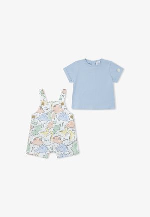 Camiseta de manga corta azul claro para niño pequeño combinada con pantalones cortos de peto blancos con estampados de dinosaurios coloridos y tirantes abotonados.