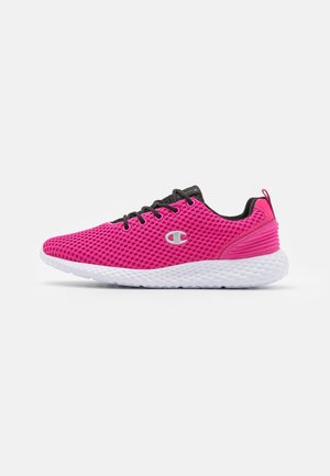 Zapatilla deportiva de malla rosa brillante con suela blanca texturizada, cordones negros y pequeño logotipo plateado en el lateral, mostrada de perfil.