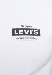 White cotton t-shirt featuring a black Levi's logo. Text includes "The Original" and "Quality never goes out of style." Simple and classic design.