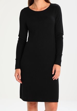 Robe en tricot noire avec manches longues, décolleté rond et poignets côtelés. Texture douce, longueur genoux avec une silhouette droite et un design minimal.