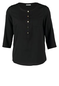 Blusa nera con maniche a tre quarti, scollo rotondo, placca con bottoni frontale con bottoni dorati e una tasca sul petto. Tessuto dalla trama liscia.