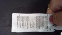 Etiqueta de cuidado de tejido blanca con texto negro. Enumera los materiales: 100% poliéster reciclado, 100% poliamida y 100% polipropileno.