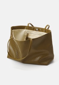 Torebka tote w oliwkowym kolorze z gładką teksturą, wyposażona w dwa uchwyty, magnetyczne zapięcie oraz kontrastowe beżowe wnętrze z kieszonką na zamek.