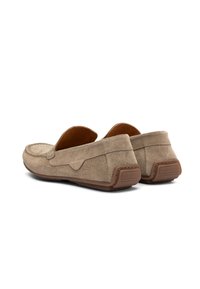 Loafers din suede bej, cu un profil jos, textură moale și talpă din cauciuc brun. Prezintă detalii cusute și un design cu vârf rotund.