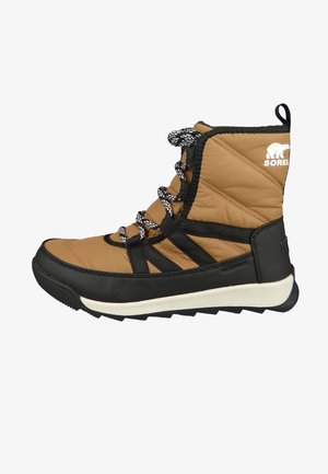 Tan veekindlad saapad, millel on tikitud ülemine osa, mustad lisad, tekstuuriga paelad ja tundlik kummist tallaga, millel on valge riba.