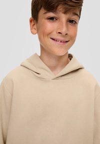 Beige hoodie met een ronde halslijn en een zachte textuur. Heeft een relaxte pasvorm en een eenvoudig, minimalistisch ontwerp.