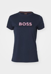 Námornická modrá krátká rukávová tričko s kulatým výstřihem, s nápisem "BOSS" vyvedeným v růžových a fialových květinových vzorech na hrudi.