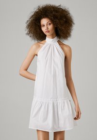 Vestido branco de alças com decote franzido e bainha em camadas, feito de tecido leve, apresentando um corte relaxado e uma textura sutil.