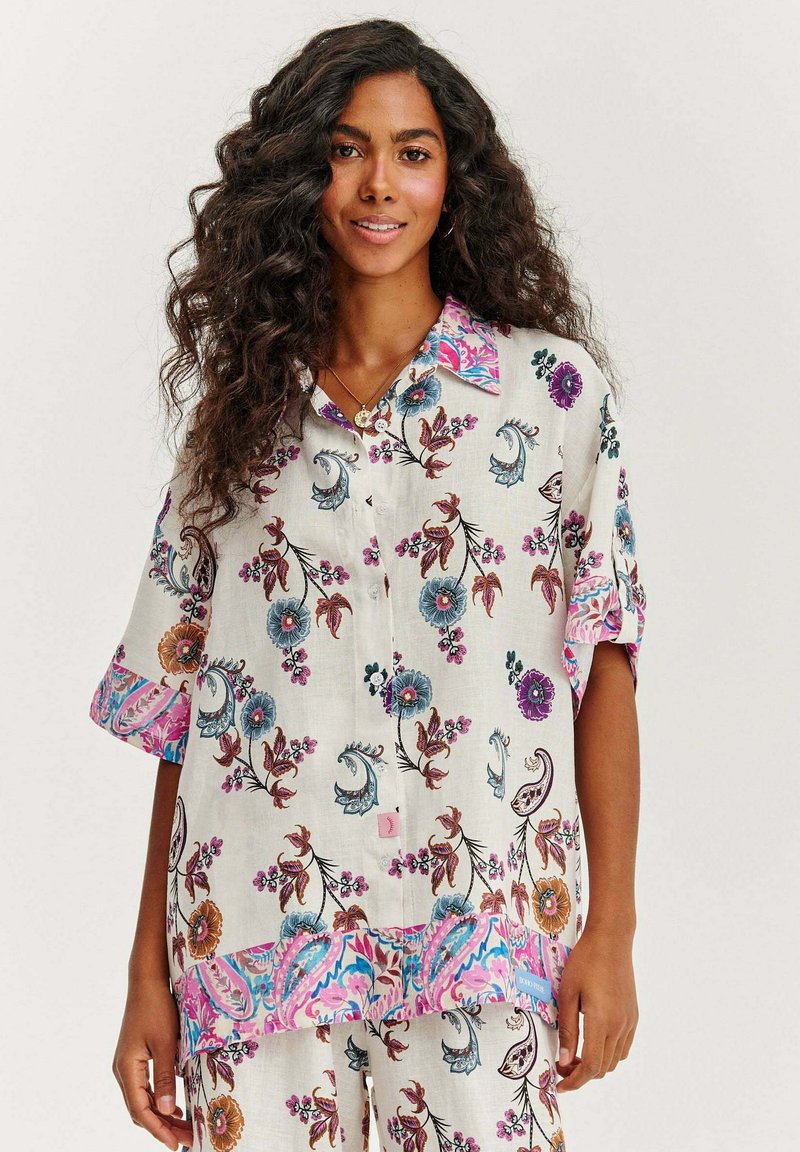 Halenka s květinovým vzorem z lehkého materiálu, s mnohobarevným límcem a lemy, krátkými rukávy a dekorativními knoflíky.