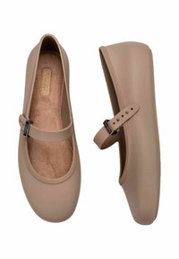 Bailarinas de color marrón claro con punta redondeada, material liso tipo goma y una delgada correa para el tobillo con herrajes de plata ajustables.