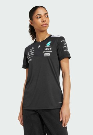 Black short-sleeve sports shirt with white stripes on shoulders, featuring sponsor logos and a lightweight, breathable fabric.