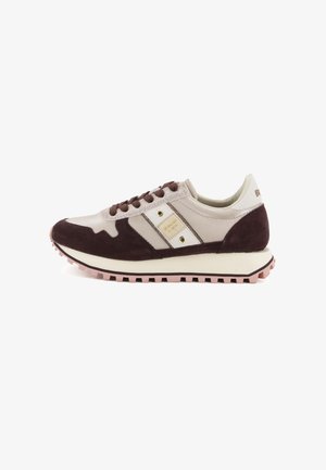 Zapatilla baja en beige y marrón oscuro con suela de goma rosa, cordones marrones y parche de logo en el panel lateral.