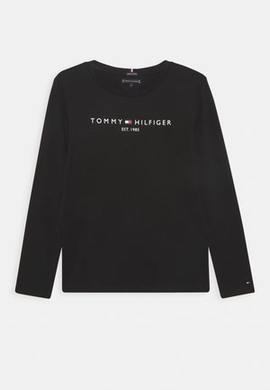 Chemise noire à manches longues avec logo Tommy Hilfiger, petite icône de drapeau et texte "EST. 1985" centré sur le devant.