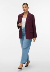 Bordeaux blazer, hvid top, lyseblå højtaljede jeans med knapf front og brune højhælede sko. Simpelt design, skræddersyet pasform.