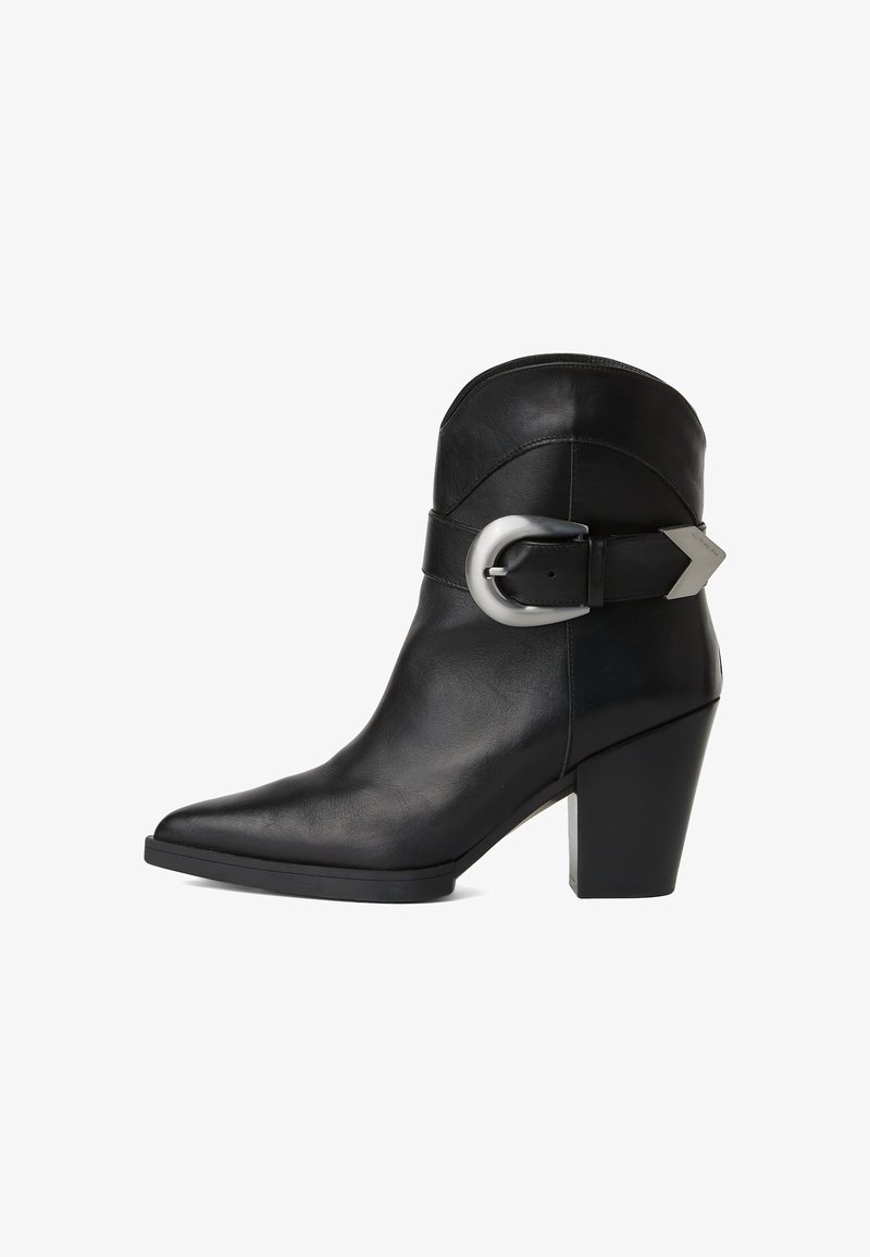 Črne usnjene gležnjarje z izostrenim nosom, masivnim peto in širokim pasom z okroglo srebrno zaponko ob strani. Gladka tekstura.