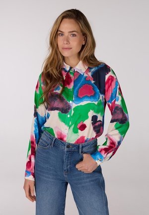 Multikleurig overhemd met lange mouwen en knoopsluiting, met een abstract bloemenpatroon in blauw, groen, roze en rood op een crèmekleurige achtergrond.