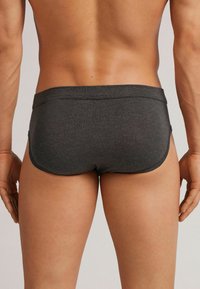 Dunkelgraue Boxer Shorts aus einem glatten, dehnbaren Material. Verfügt über ein tiefgeschnittenes Design und dezente Nähte entlang der Kanten.