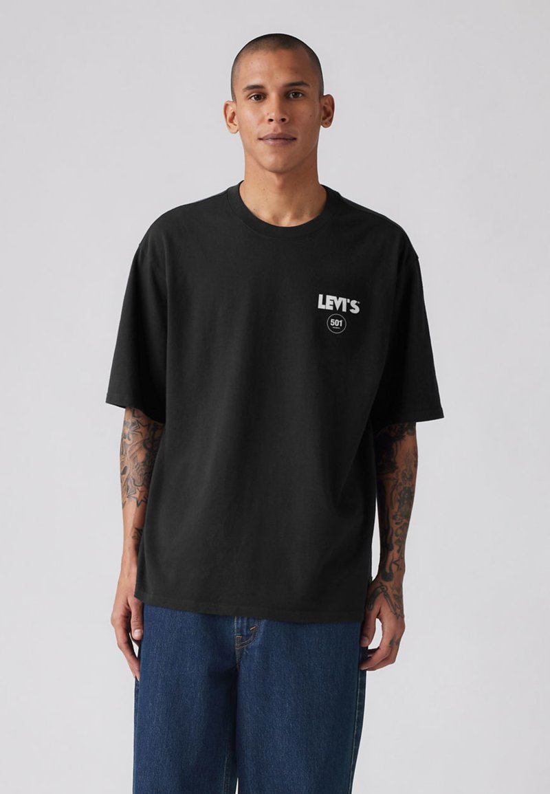 Zwart katoenen T-shirt met een ronde hals en korte mouwen, met een wit Levi's-logo op de linkerborst. Losse pasvorm, casual ontwerp.