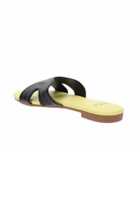 Sandalo piatto nero con una soletta gialla e suola marrone. Presenta cinturini sovrapposti realizzati in un materiale flessibile.