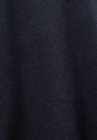 Gros plan d'un tissu noir doux avec une texture fine et de légers plis.