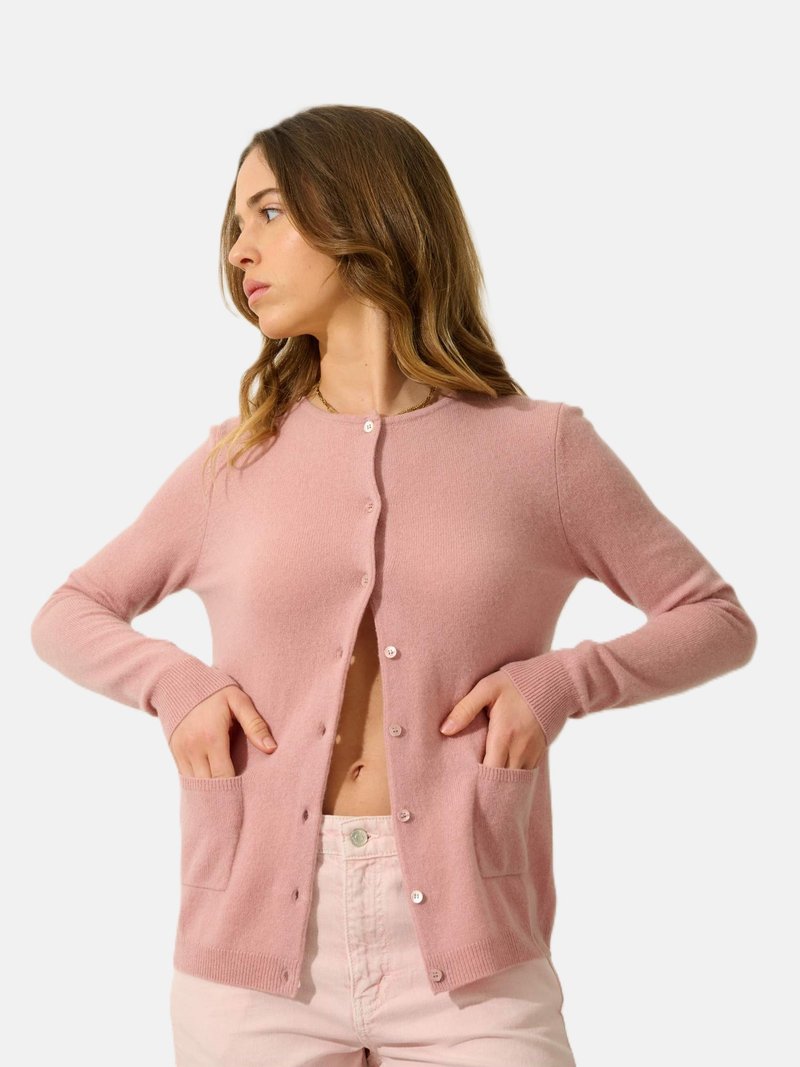 Lichtroze cardigan van zacht materiaal, met een knoopsluiting aan de voorkant, lange mouwen en twee voorzakken. Over het algemeen een gladde textuur.