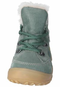 Bota verde de ante con parte superior de malla texturizada, forro de piel en el cuello, ganchos de encaje negros y suela de goma flexible.