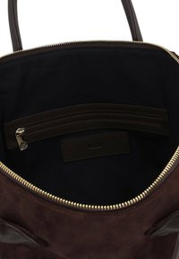Barna velúr kézitáska belseje sötét béléssel, cipzáras zsebbel és bőr címkével. Arany színű cipzár hardver a tetején.