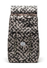 Batoh s béžovým a čiernym leopardím vzorom, vyrobený z odolnej látky; disponuje rolovacím vrchom, dvoma prednými popruhmi a malou nášivkou s logom.