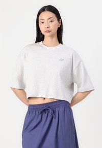 Lys grå kortermet t-skjorte med rund hals. Har en liten mørk logo foran. Kombinert med marineblå shorts med snøring.