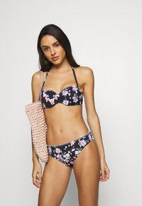 Fekete virágmintás bikinit rózsaszín és fehér virágokkal; texturált anyag; pánt nélküli felső, párnázott kosarakkal; illő bikini alsó; nagy szőtt táska.