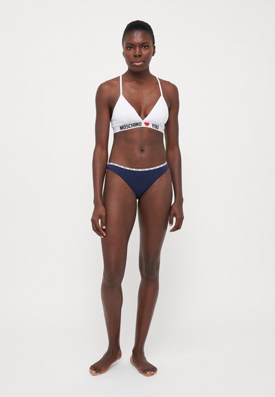 White bikini top with "MOSCHINO ♥ YOU" text, adjustable straps; navy blue bikini bottom with branded waistband. Smooth material, minimal design.