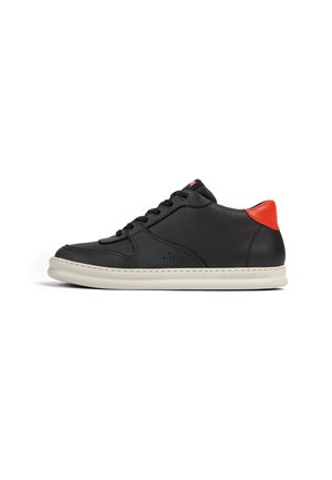 Black leather sneaker with a smooth texture, red heel accent, white sole, and black laces, featuring subtle perforations on the sides.