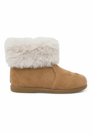 Tan suède enkellaarsje met een fluffy crèmekleurige faux fur manchet, ronde neus en subtiele stikseldetails aan de zijkant. Platte rubberen zool.