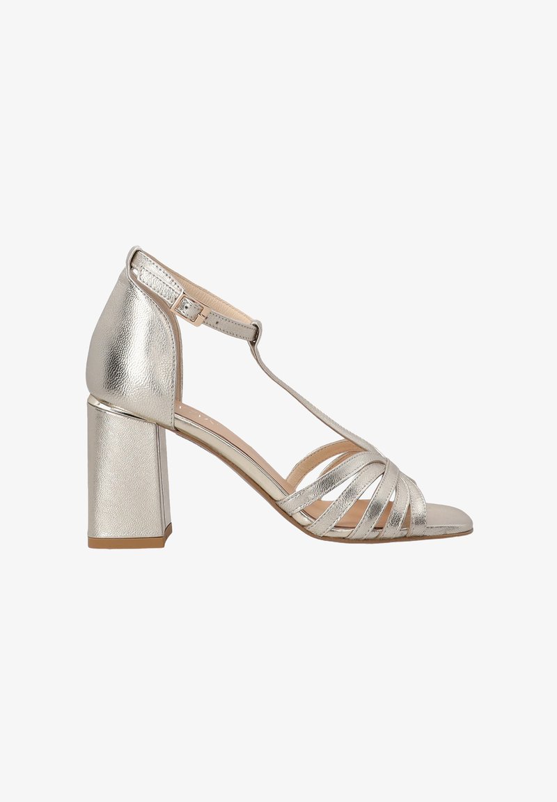 Dámské stříbrné sandály s blokovým podpatkem, které mají více křížených pásků, nastavitelnou přezku na kotníku a hladký kovový povrch.