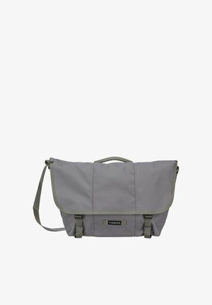 Graue Timbuk2 Messenger-Tasche mit Klappverschluss, verstellbarem Schultergurt, Tragegriff oben und zwei vorderen Schnallenverschlüssen.