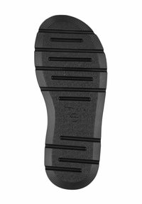 Black rubber shoe sole with textured surface, featuring horizontal ridges and grooves for traction. Rounded toe and slightly raised heel.