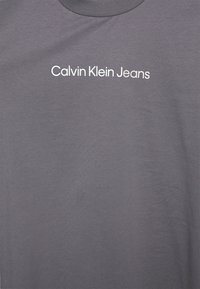 T-shirt grigio a maniche corte realizzato in morbido cotone, con la scritta "Calvin Klein Jeans" in bianco, centrata sul petto.