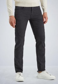 Pantalons slim gris foncé en mélange de coton résistant, dotés d'un motif texturé subtil et de poches frontales. Associés à des baskets blanches.