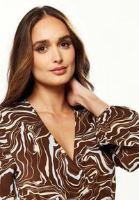 Brown dress with a swirling abstract pattern in beige and light blue. Features a deep V-neckline and puffed sleeves. Smooth fabric texture.