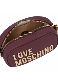 Piccola borsa a tracolla color marrone porpora con la scritta dorata "LOVE MOSCHINO" e una cerniera parzialmente aperta che rivela l'interno beige.