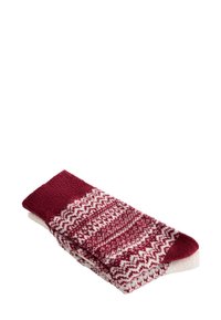 Hajtogatott pár gyapjú zokni vörös és fehér bonyolult geometriai és cikkcakk mintákkal.