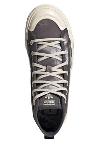 Šedá textilní teniska s krémovým gumovým špičkovým krytem, béžovými tkaničkami, logem na jazyku a strukturovanou mezipodešví. Navržena pro běžné nošení.