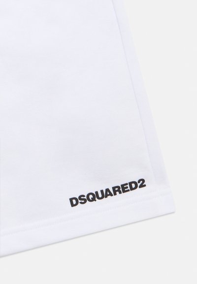 Coin de tissu blanc avec logo de marque noir "DSQUARED2" imprimé près de l'ourlet.